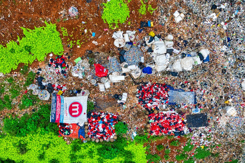 A collection of discarded household items and building debris scattered on a paved outdoor surface. Prominent in the foreground are wooden garden furniture, including a slatted garden chair and a smal